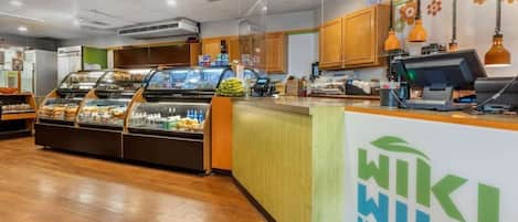 Un mercado de alimentos limpio y moderno, con vitrinas de vidrio y una barra con un logotipo.