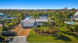 A residential property with a large house, a swimming pool, and a well-maintained garden. - beautiful views and sunsets in the gorgeous ground level home! (Sanibel)
