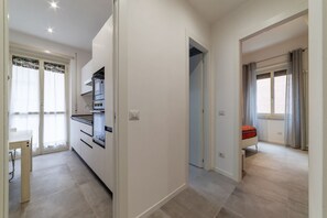 A modern apartment with a kitchen, a dining area, and a bedroom.