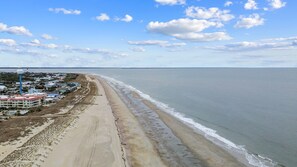 Na praia, espreguiçadeiras, toalhas de praia 