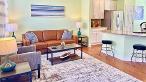 A living room with a brown sofa, two lamps, a coffee table, and a rug. - Townhome in Village of 5 Points, 3BDR 2.5BA Sleeps 6-8. Saturday-Saturday (Lewes)