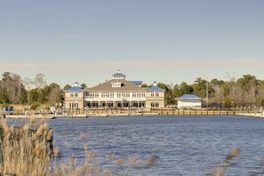 Waterfront property with a central tower, surrounded by a dock and adjacent to a body of water.