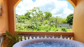 Un jacuzzi con vistas a la vegetación y un cartel que dice "RELAX & REVIVE".