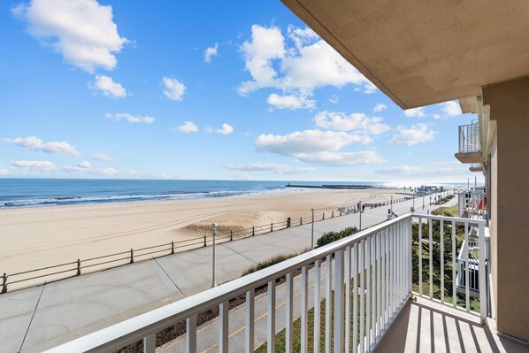 A balcony with a view of a beach and ocean.