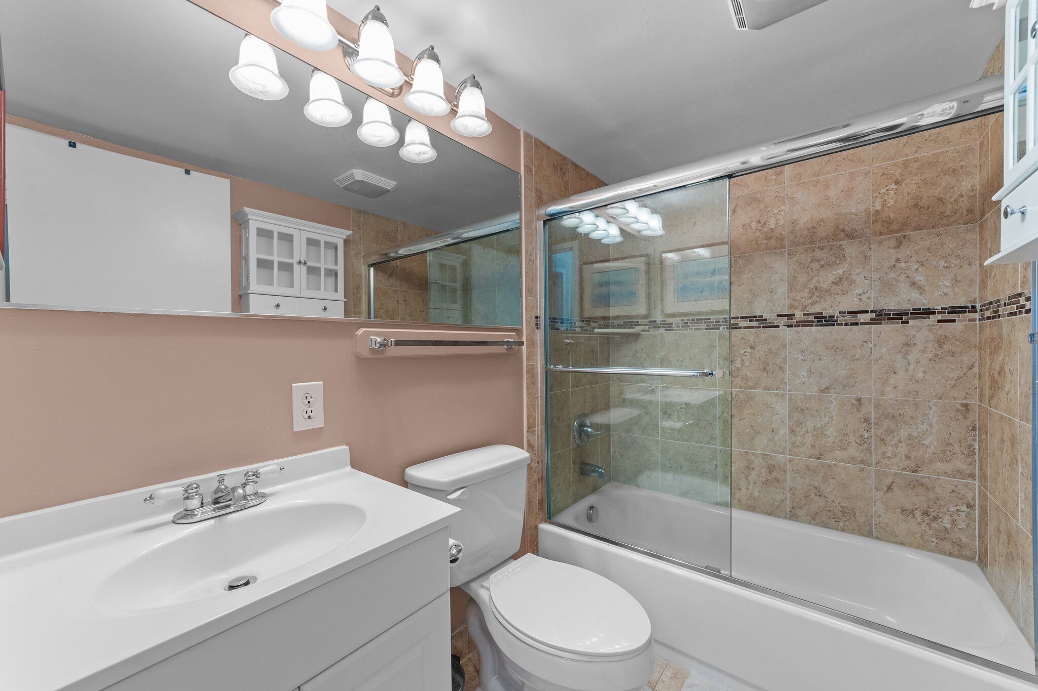 A modern bathroom with a glass-enclosed shower, a white sink, and a toilet.