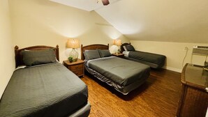 A bedroom with two single beds, a ceiling fan, and a nightstand with a lamp. - “3bdrm Barn Apt” @ Sunset Pointe (Lincoln)