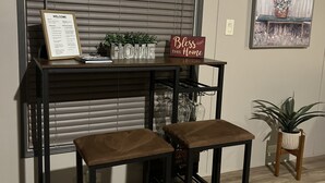 A reception desk with a welcome sign, a 'Bless this Home' sign, and a framed picture on the wall.