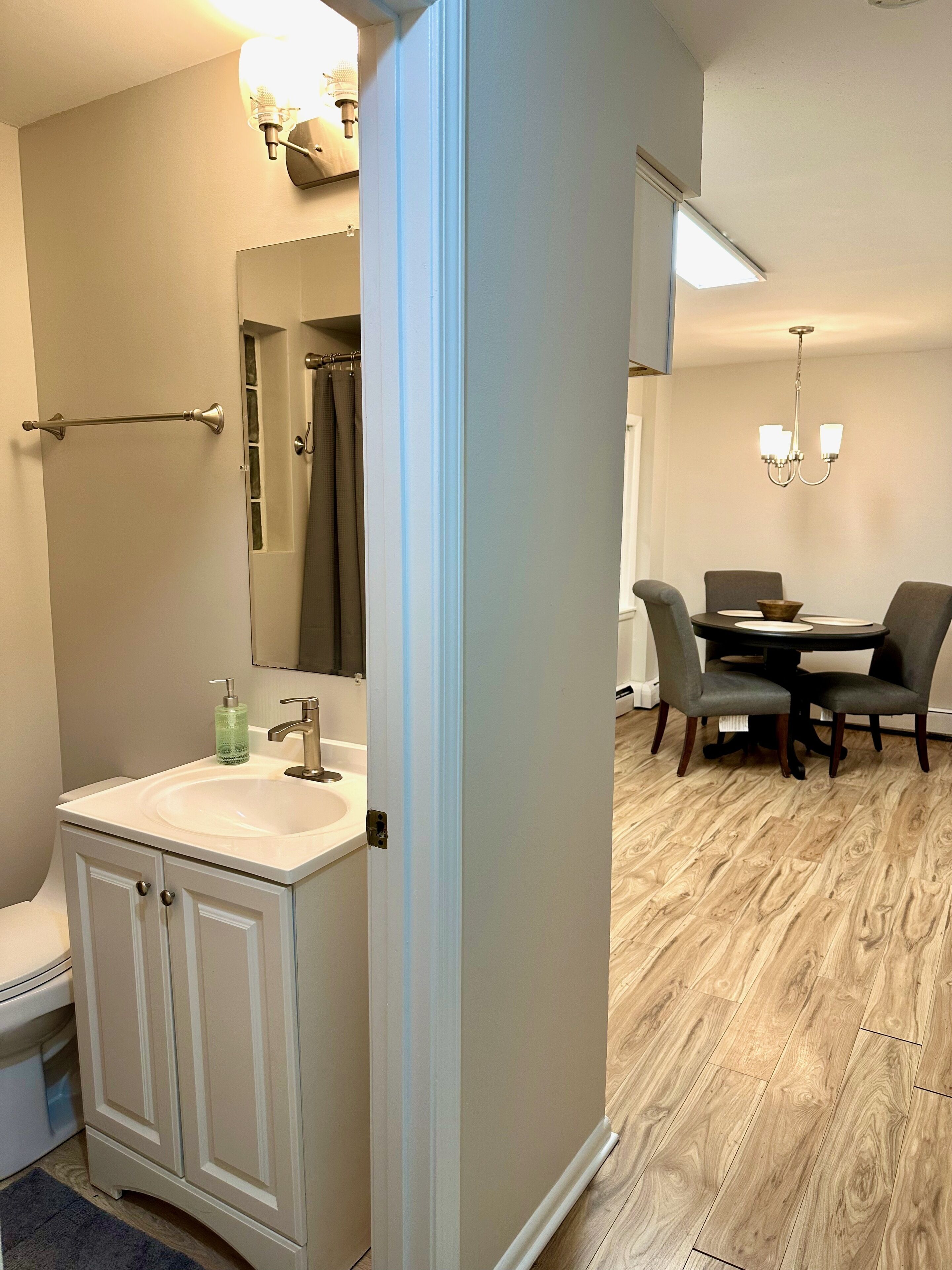 A bathroom with a sink, mirror, and shower curtain.