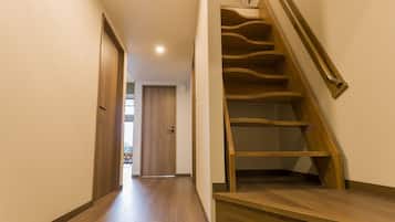 A wooden staircase with a handrail, leading to an upper floor.