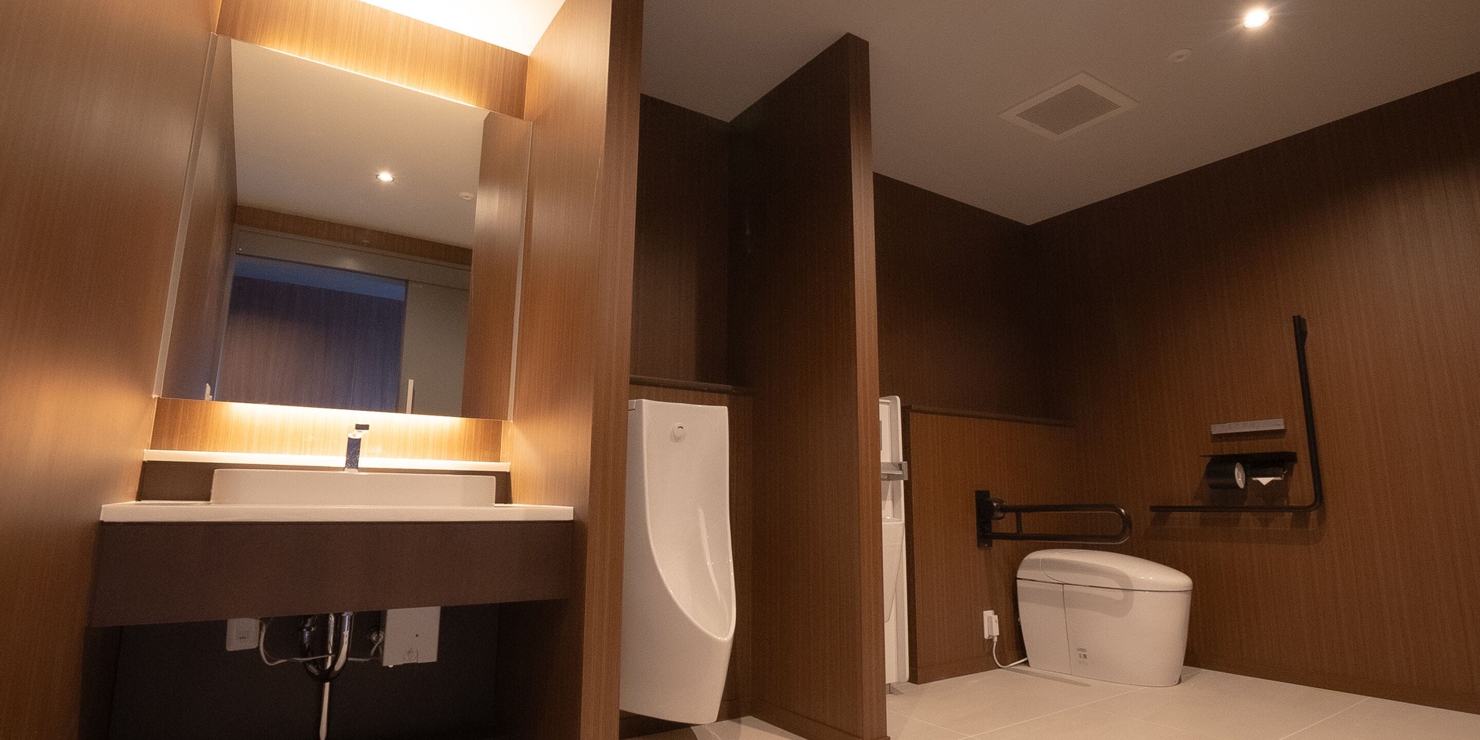 Et moderne badeværelse med en trækommode, toilet og bruseniche.