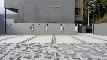 An EV charging station area with a modern building in the background.