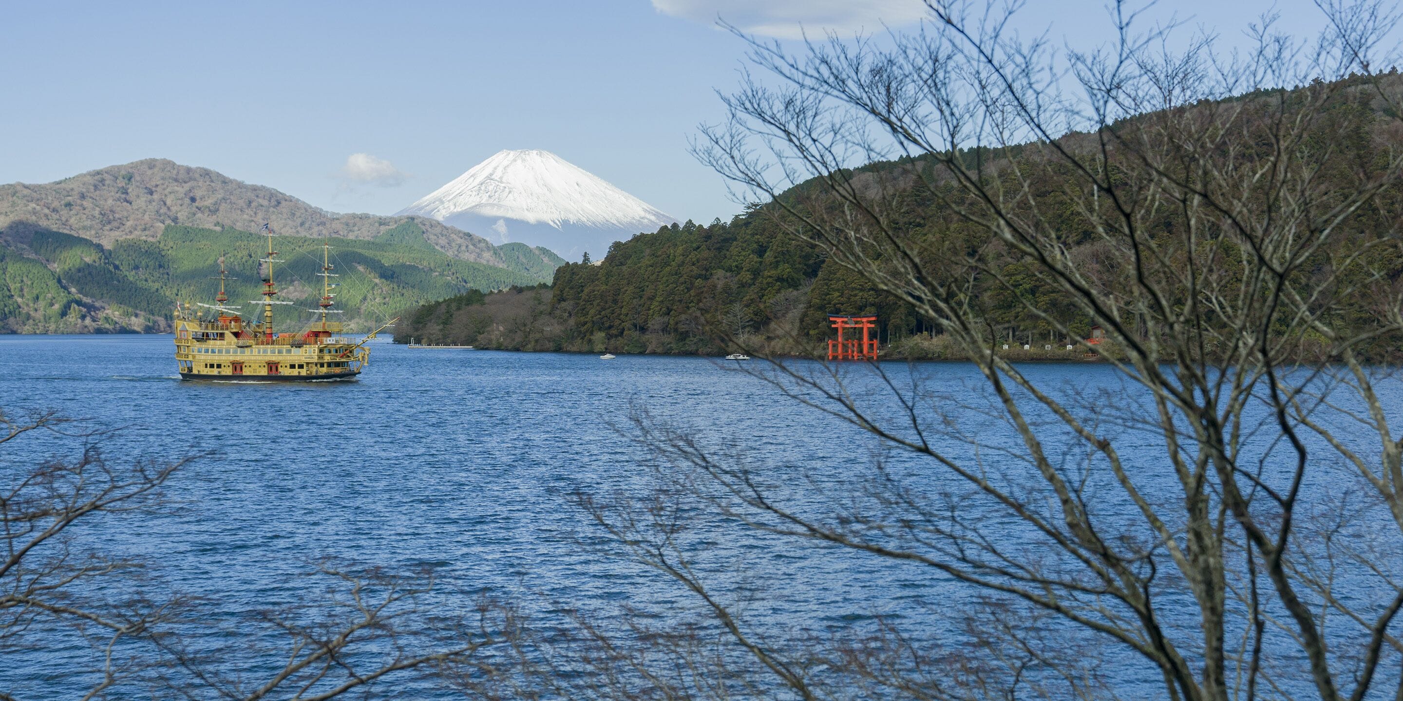 A river with a boat, a mountain, and a forested area.