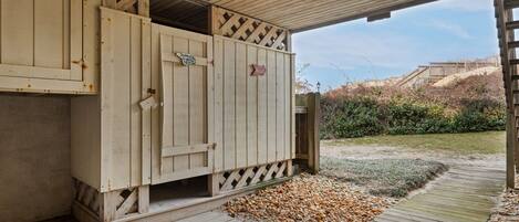 A wooden structure with a door, a sign indicating a beach view, and a pathway leading to a beach.