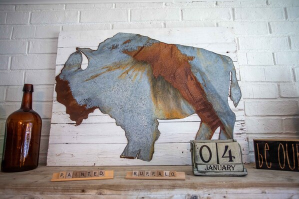 A rustic buffalo painting on a white brick wall, a brown bottle, and a calendar marked "04 January".
