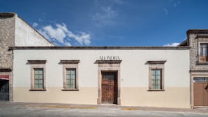 A building with the name 'ALONDA' above the entrance, featuring a stone facade and a large wooden door. - Casa Alondra (Morelia)