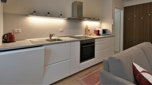 Een moderne keuken met witte kasten, een roestvrijstalen spoelbak en een inbouwoven.