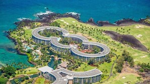 Un resort con una distribución circular, rodeado de exuberante vegetación y un campo de golf.