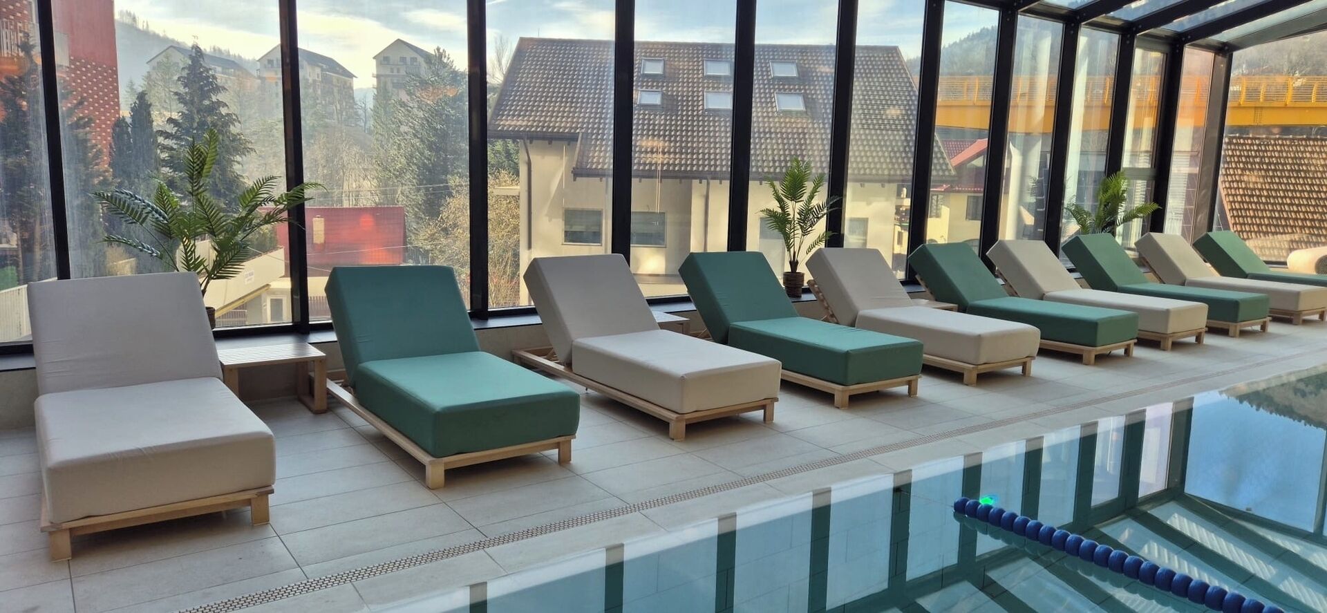 A poolside area with lounge chairs and a glass-enclosed pool.