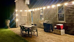 A wooden house with a sign reading "Old Atwood House and Museum" and a patio with a table and chairs. - Madaket Farmhouse- Walk to Beach and Sunsets- Near Bike Path -Nantucket (Nantucket)