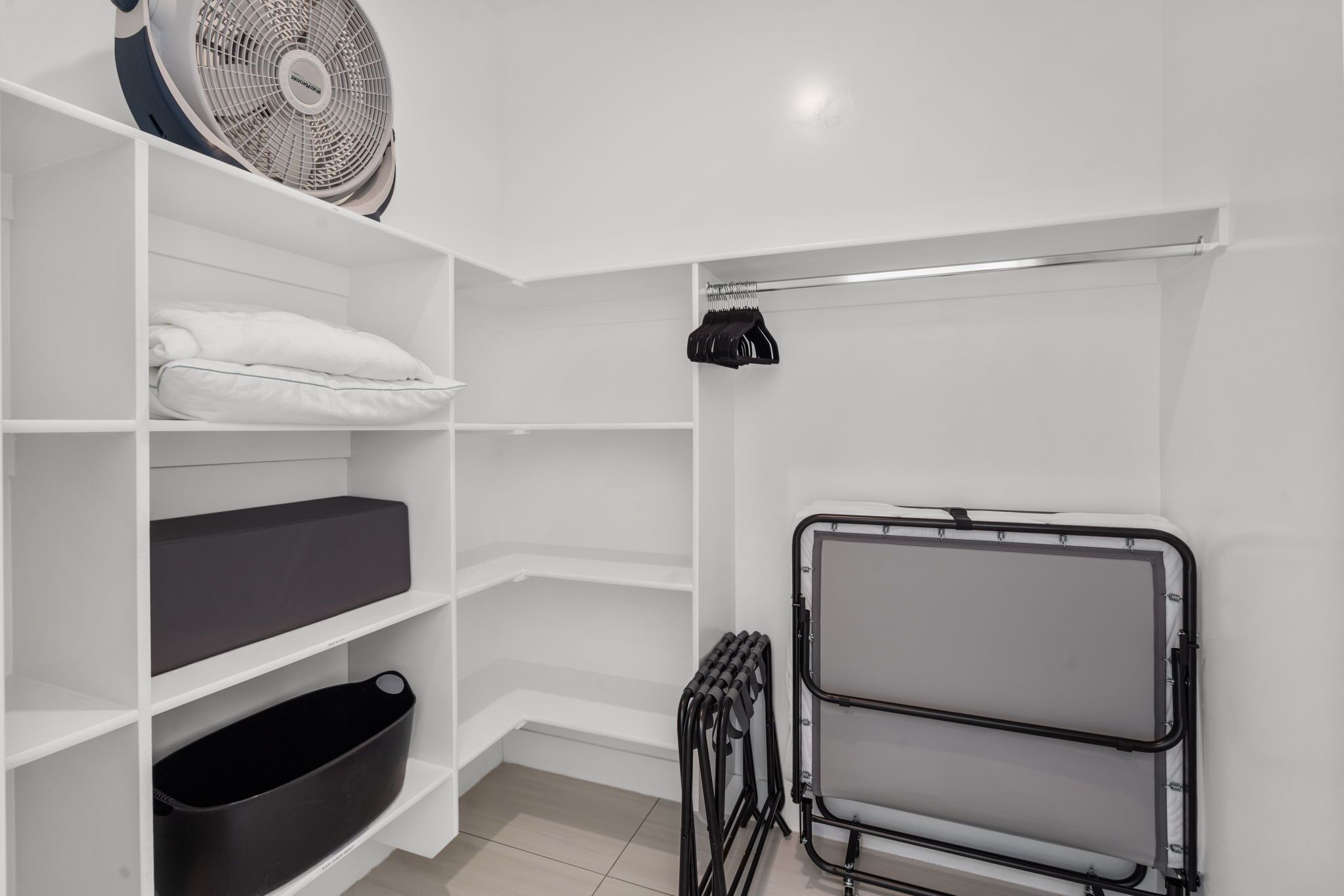 Een witte kast met planken, een radiator en een ventilator.