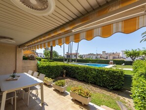 Eine Außenpatio mit Tisch und Stühlen, ein Swimmingpool und Blick auf die Nachbarschaft.
