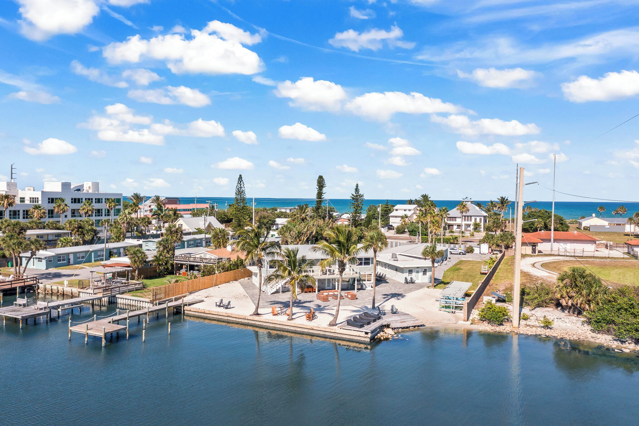 A marina with docked boats, a sandy beach, and a clear blue sky.