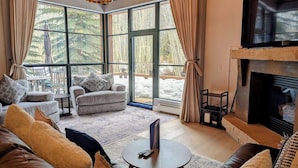 Un salón amplio con chimenea, ventanas grandes y asientos cómodos.