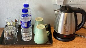 A tray with a water bottle, a glass, and a kettle on a wooden table. - SUPER 8 HOTEL ALOR SETAR (Alor Setar)
