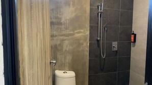A bathroom with a toilet, a shower with a handheld showerhead, and a window above the shower. - SUPER 8 HOTEL ALOR SETAR (Alor Setar)