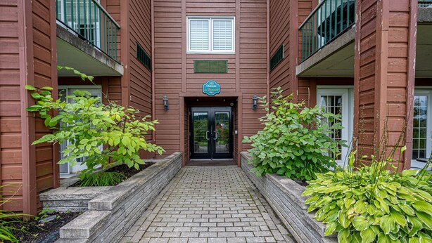 A brick building with a central entrance, two balconies, and a sign above the door. - Chambre 2 Lits/Room 2 beds (Saint-sauveur)