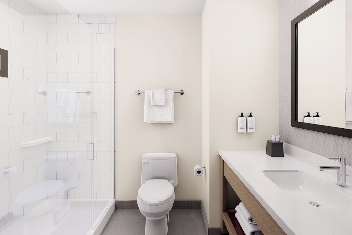 Une salle de bain moderne équipée d’une douche, de toilettes et d’un meuble-lavabo.