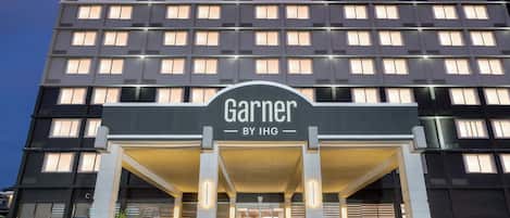 A hotel entrance with a sign reading 'Garner by IHG.'
