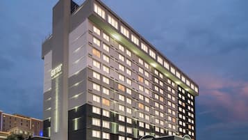 A multi-story hotel building with a prominent entrance and signage.