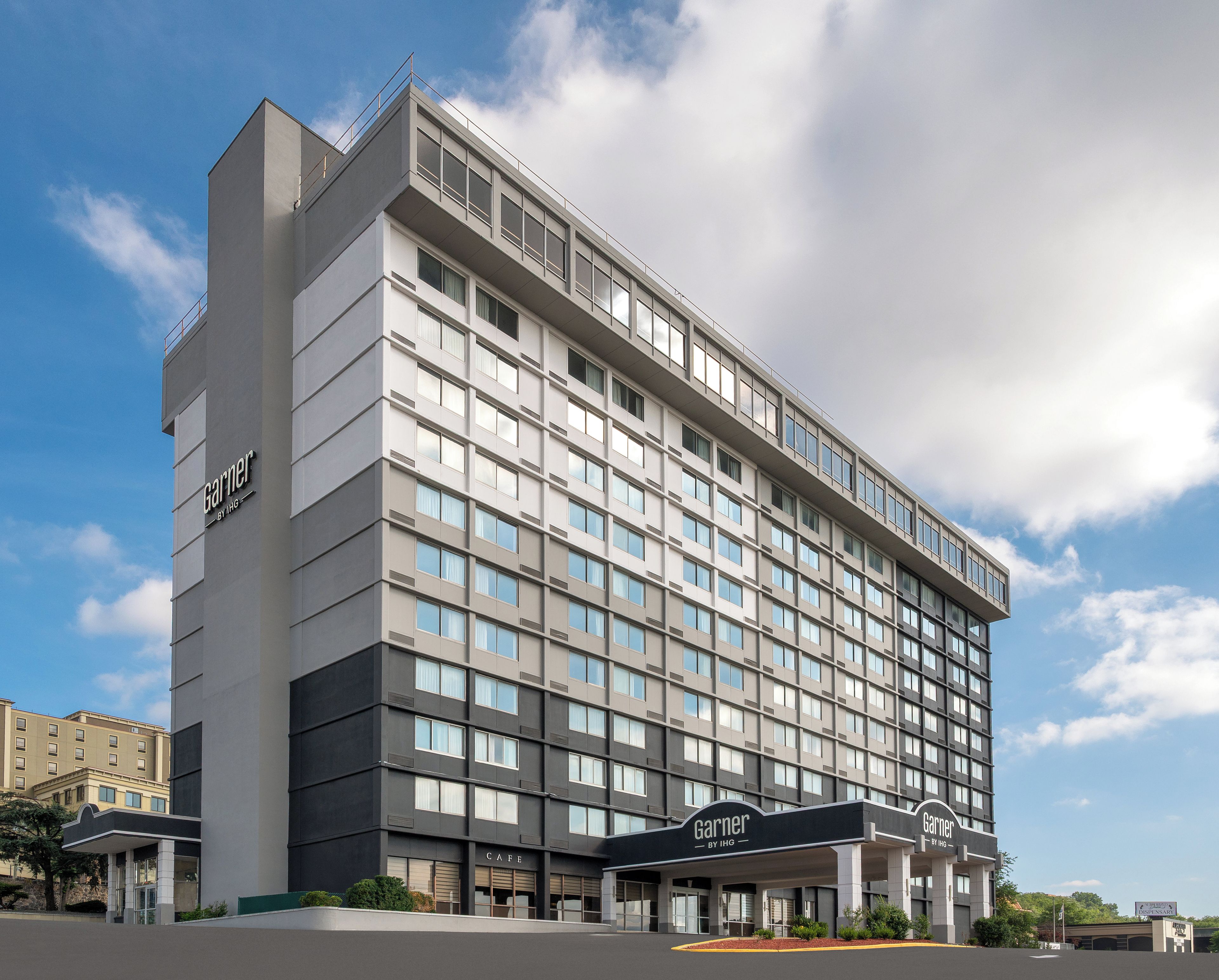 A multi-story hotel with a prominent 'Garnier' sign, a cafe, and a dispensary.