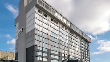 A multi-story hotel with a prominent 'Garnier' sign, a cafe, and a dispensary.