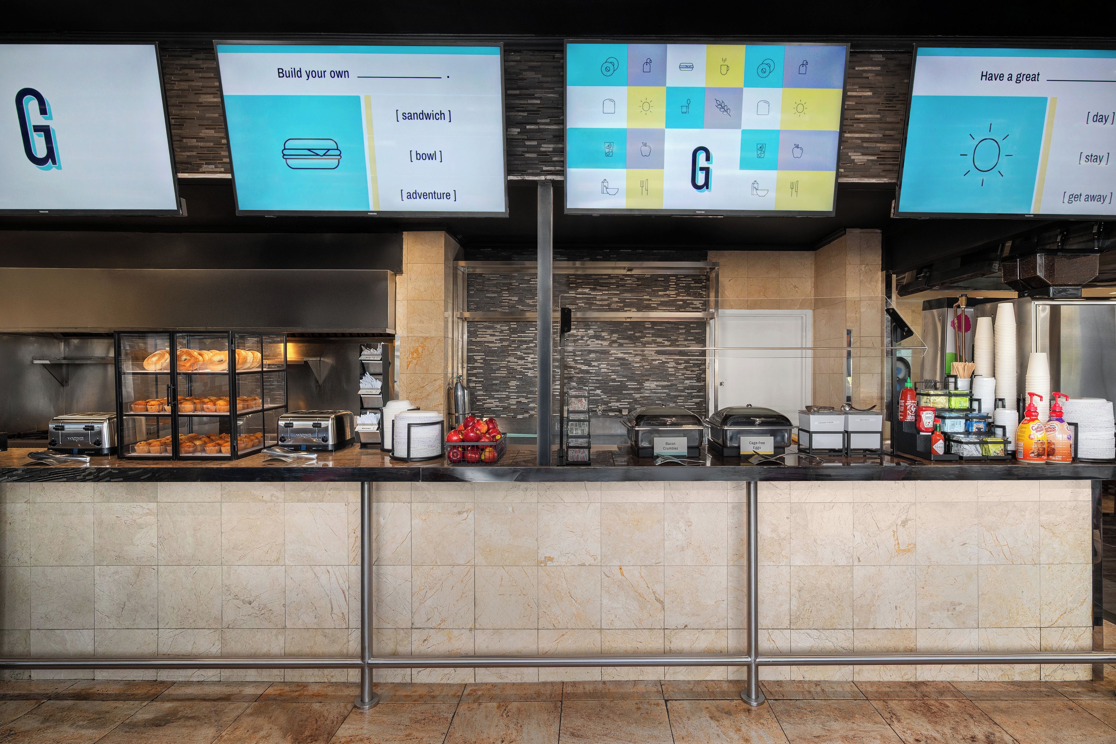A buffet area with a variety of food options, including sandwiches, bowls, and apples.