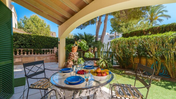 An outdoor patio with a round table set for dining, surrounded by chairs. - Sunwing Beach by Interhome (Port d'Alcúdia)