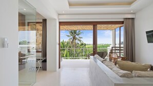 Una sala de estar moderna con un ventanal grande, un sofá y vistas a una palmera.