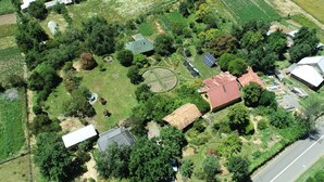 An aerial view of a residential area with multiple houses, green fields, and a road.