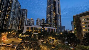A high-rise urban area with modern buildings, a well-lit intersection, and a clear sky.