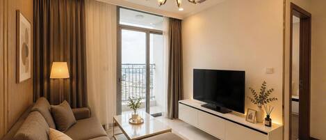 A modern living room with a sofa, TV, and a balcony with a city view.
