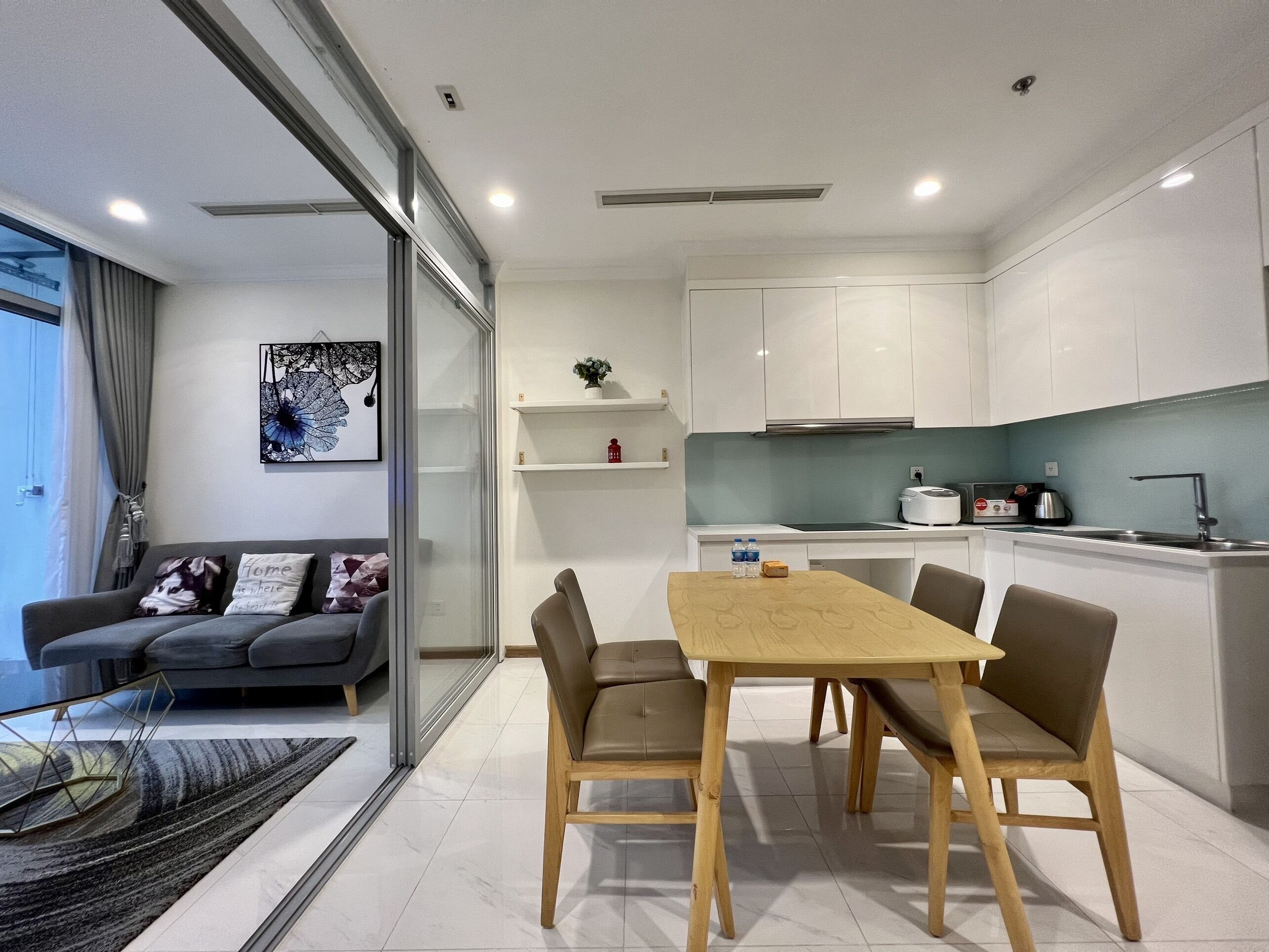 Um apartamento moderno com sala de jantar, cozinha e sala de estar.