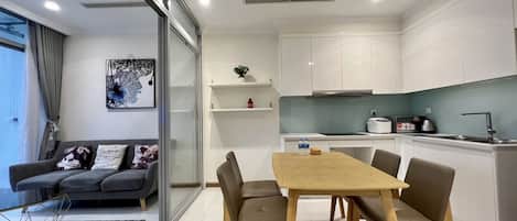 A modern apartment with a dining area, kitchen, and living room.