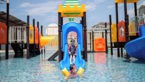 A children's water play area with a slide and various play structures.