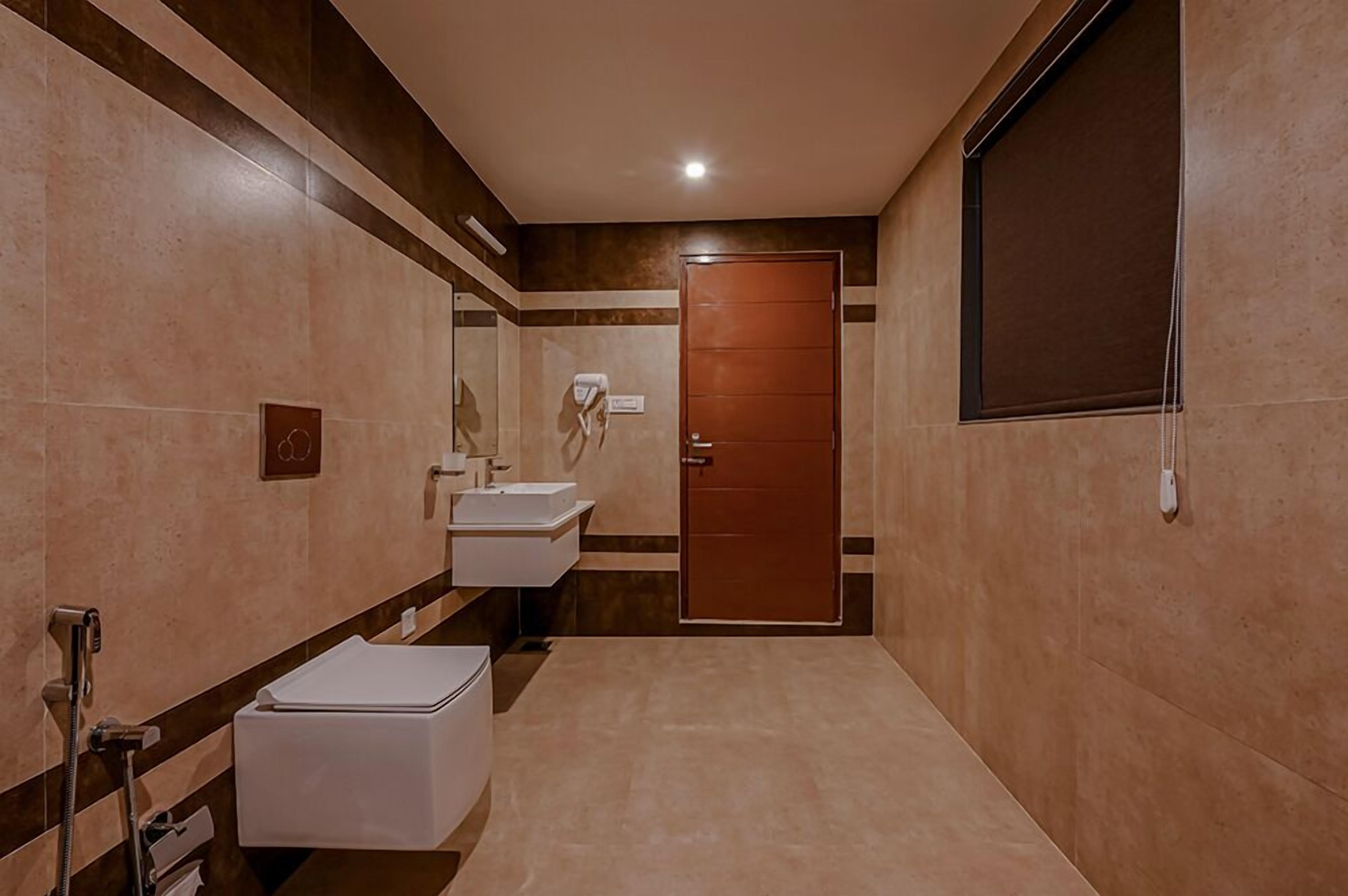 Un baño moderno con dos lavamanos, un inodoro y una ducha.