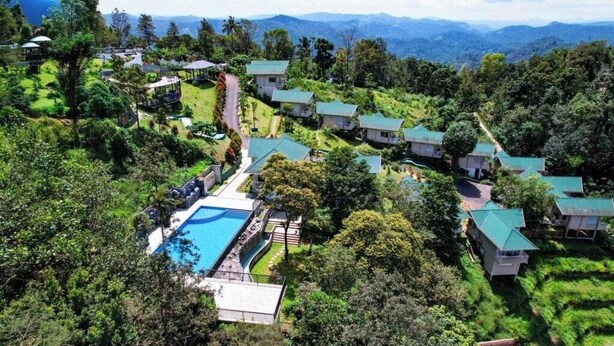 A resort with multiple bungalow-style buildings, a central swimming pool, and lush greenery. - Aveda Munnar Mountains and Mist (Devikolam)
