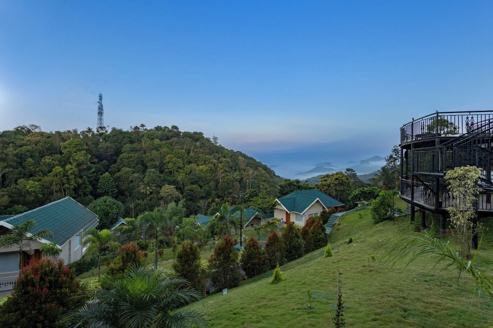 A hillside residential area with houses, a prominent tower, and a staircase structure.