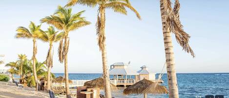 Rannalla, aurinkotuoleja, rantapyyhkeitä