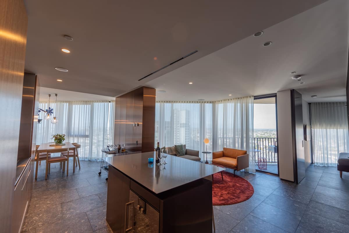 A modern living room with a large island, a sofa, and a dining area.