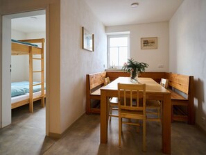 A room with a bunk bed, wooden dining table, chairs, and benches. - Jizerky Paws & Sauna by Interhome (Tanvald)